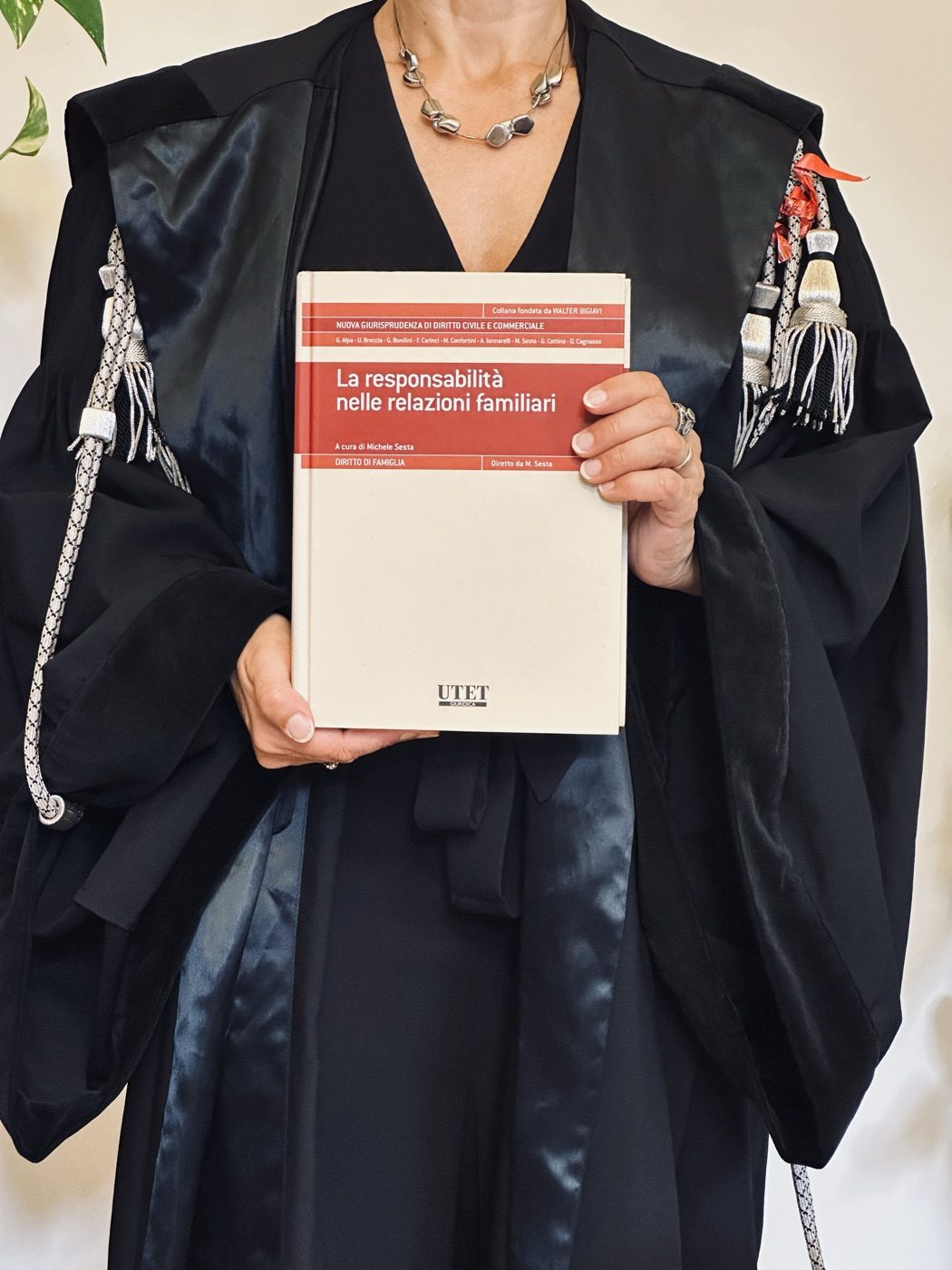 Avv. Paola Spadini in toga con un volume sulla responsabilità nelle relazioni familiari